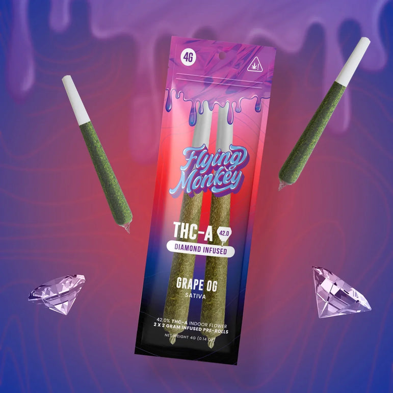 Flying Monkey Diamond Infused Pre-Rolls in a vibrant pink and blue 4g pouch with two green pre-rolls and diamond graphics